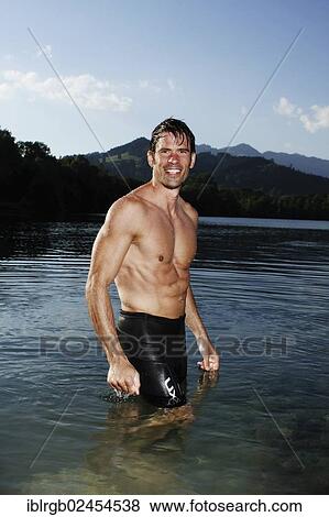 "Man standing in a lake in Sonthofen, Allgaeu, Bavaria, Germany, Europe" View Large Photo Image Stock Photo - "Man standing in a lake in Sonthofen, Allgaeu, Bavaria, Germany, Europe". Fotosearch