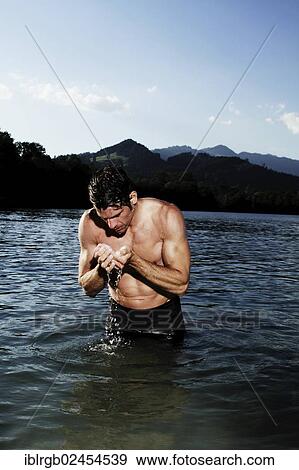 Stock Photo - "Man standing in a lake in Sonthofen, Allgaeu, Bavaria, Germany, Europe". Fotosearch
