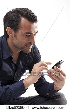 Stock Image - Man typing on a mobile phone. Fotosearch