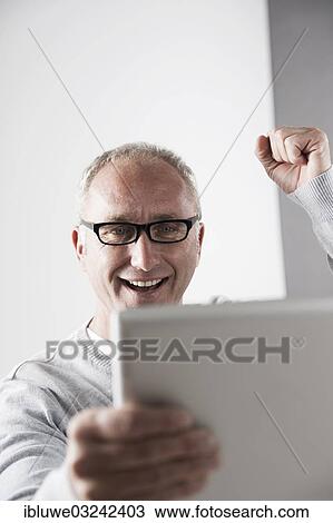 "Man using a tablet PC, cheering, Mannheim, Baden-Wurttemberg, Germany, Europe" View Large Photo Image Stock Image - "Man using a tablet PC, cheering, Mannheim, Baden-Wurttemberg, Germany, Europe". Fotosearch