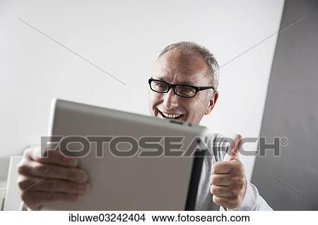"Man using a tablet PC, making a thumbs-up gesture, Mannheim, Baden-Wurttemberg, Germany, Europe" View Large Photo Image Picture - "Man using a tablet PC, making a thumbs-up gesture, Mannheim, Baden-Wurttemberg, Germany, Europe". Fotosearch