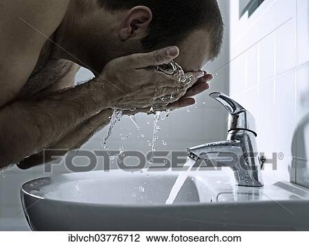 Stock Image - Man washing his face with both hands. Fotosearch