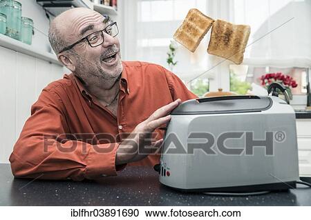 "Man watching 2 slices of toast being ejected from a toaster, Germany, Europe" View Large Photo Image Stock Image - "Man watching 2 slices of toast being ejected from a toaster, Germany, Europe". Fotosearch