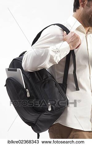 Man wearing a backpack from which an iPad is sticking out View Large Photo Image Stock Image - Man wearing a backpack from which an iPad is sticking out. Fotosearch