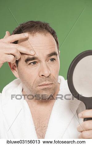 "Man wearing a bathrobe observing himself critically in a hand mirror, Mannheim, Baden-Wurttemberg, Germany, Europe" View Large Photo Image Stock Image - "Man wearing a bathrobe observing himself critically in a hand mirror, Mannheim, Baden-Wurttemberg, Germany, Europe". Fotosearch