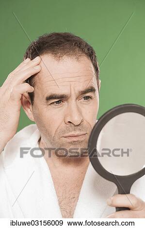 "Man wearing a bathrobe observing himself critically in a hand mirror, Mannheim, Baden-Wurttemberg, Germany, Europe" View Large Photo Image Stock Photo - "Man wearing a bathrobe observing himself critically in a hand mirror, Mannheim, Baden-Wurttemberg, Germany, Europe". Fotosearch