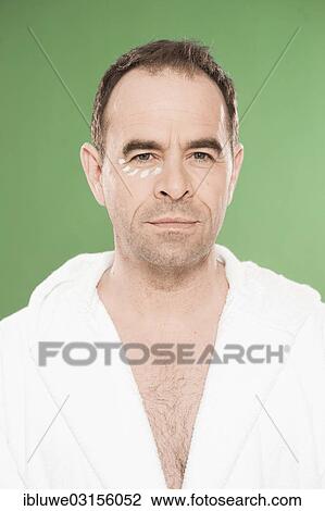 Stock Image - "Man wearing a bathrobe with eye cream, Mannheim, Baden-Wurttemberg, Germany, Europe". Fotosearch
