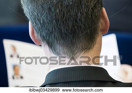 Stock Photo - "Man wearing a suit, conference participant, reading a newspaper, rear view with the back of his head, Munich, Upper Bavaria, Bavaria, Germany, Europe". Fotosearch