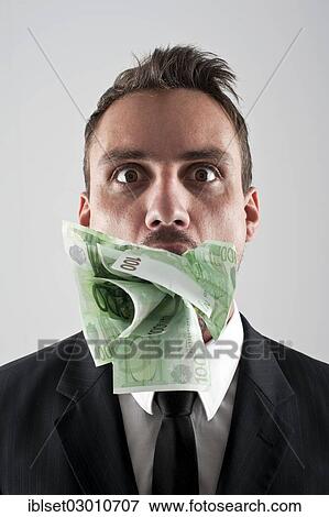 Man wearing a suit with 100 EUR banknotes stuffed in his mouth View Large Photo Image Stock Photo - Man wearing a suit with 100 EUR banknotes stuffed in his mouth. Fotosearch