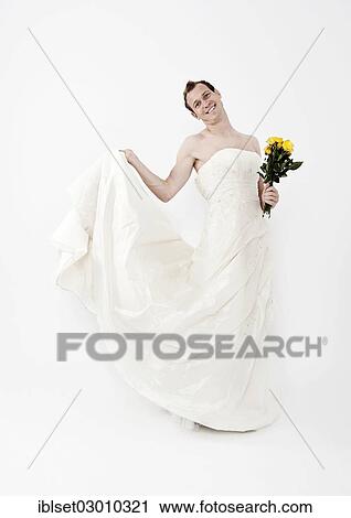 Stock Image - "Man wearing a wedding dress and holding a bridal bouquet, Austria, Europe". Fotosearch
