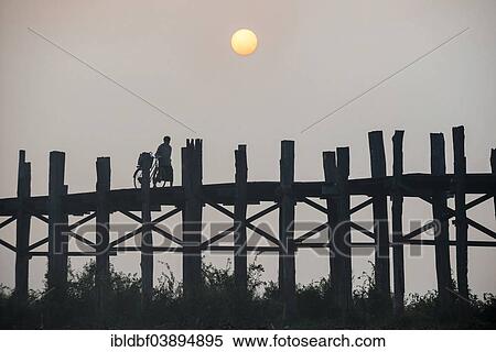 "Man with a bicycle on a teak bridge, U Bein Bridge over Taungthaman Lake at sunrise, Amarapura, Mandalay Division, Myanmar, Asia" View Large Photo Image Stock Photography - "Man with a bicycle on a teak bridge, U Bein Bridge over Taungthaman Lake at sunrise, Amarapura, Mandalay Division, Myanmar, Asia". Fotosearch