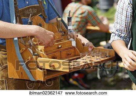 Stock Photo - "Man with a hawker's tray selling liquor, Pfeifertag festival on Niedergadenalm alp, Strobl, Salzburg state, Salzkammergut resort area, Austria, Europe". Fotosearch