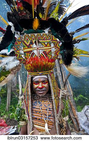 "Man with a huge headdress, colourful decorations and face paint is celebrating at the traditional Sing Sing gathering in the Highlands, Paya, Papua New Guinea, Oceania" View Large Photo Image Stock Image - "Man with a huge headdress, colourful decorations and face paint is celebrating at the traditional Sing Sing gathering in the Highlands, Paya, Papua New Guinea, Oceania". Fotosearch