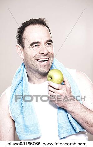 "Man with a towel around her neck holding an apple, Mannheim, Baden-Wurttemberg, Germany, Europe" View Large Photo Image Stock Photography - "Man with a towel around her neck holding an apple, Mannheim, Baden-Wurttemberg, Germany, Europe". Fotosearch