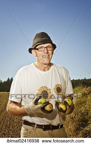 Man with apples on the field View Large Photo Image Stock Photo - Man with apples on the field. Fotosearch