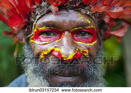 "Man with colourful decorations and face paint is celebrating at the traditional Sing Sing gathering in the Highlands, Paya, Papua New Guinea, Oceania" View Large Photo Image Picture - "Man with colourful decorations and face paint is celebrating at the traditional Sing Sing gathering in the Highlands, Paya, Papua New Guinea, Oceania". Fotosearch