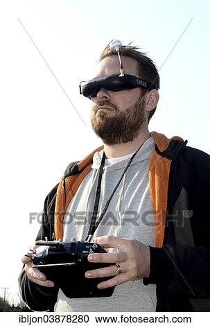 Man with FPV goggles and FUTUBA operator console to control a drone View Large Photo Image Stock Image - Man with FPV goggles and FUTUBA operator console to control a drone. Fotosearch