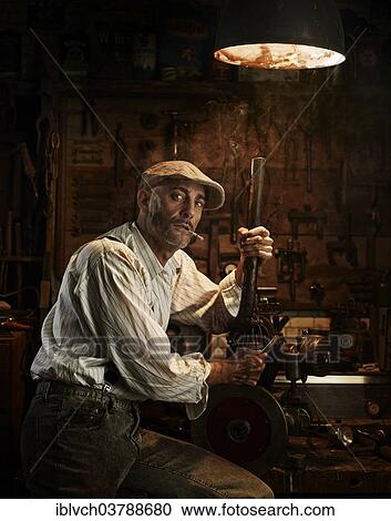 Man with hat and cigarette repairing a motor in a workshop View Large Photo Image Stock Image - Man with hat and cigarette repairing a motor in a workshop. Fotosearch