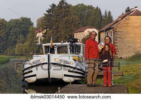 "Man, woman and girl with brought bread in the early morning, standing in front of a houseboat on the Canal des Vosges, formerly Canal de l'Est, Selles, Vesoul, Region Franche-Comte, Dep. Haute-Saone, France, Europe" View Large Photo Image Stock Image - "Man, woman and girl with brought bread in the early morning, standing in front of a houseboat on the Canal des Vosges, formerly Canal de l'Est, Selles, Vesoul, Region Franche-Comte, Dep. Haute-Saone, France, Europe". Fotosearch
