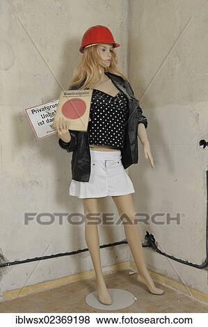 Stock Photo - "Mannequin with a hard hat on a building site, holding a construction approval and a """"no entry"""" sign in her hand. Germany, Europe". Fotosearch