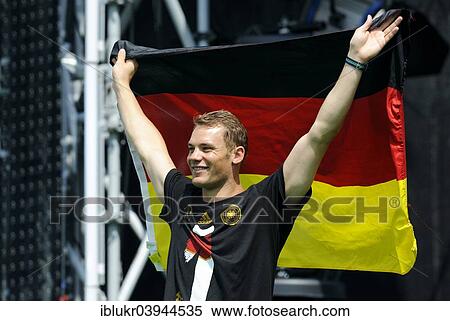 Stock Photography - "Manuel Neuer with the Germany flag, reception of the German national team after their victory at the FIFA World Cup 2014, fan party at the Brandenburg Gate, Berlin, Germany, Europe". Fotosearch