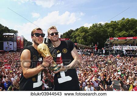 Stock Image - "Mario Gotze and Andre Schurrle with the trophy, reception of the German national team after their victory at the FIFA World Cup 2014, fan party at the Brandenburg Gate, Berlin, Germany, Europe". Fotosearch