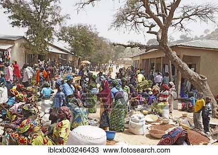 Stock Image - "Market scene, women wearing colourful dresses, selling millet, Tourou, Far North, Cameroon, Africa". Fotosearch