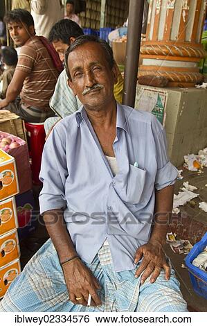 "Market vendor at a stall during a cigarette break, Babu Bazar, Old Dhaka, Dhaka, Bangladesh, South Asia, Asia" View Large Photo Image Stock Photograph - "Market vendor at a stall during a cigarette break, Babu Bazar, Old Dhaka, Dhaka, Bangladesh, South Asia, Asia". Fotosearch