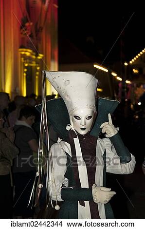 Picture - "Mask wearer during the parade in front of the historic municipal church, Venetian Fair, on the historic Marktplatz market square, Ludwigsburg, Baden-Wuerttemberg, Germany, Europe". Fotosearch