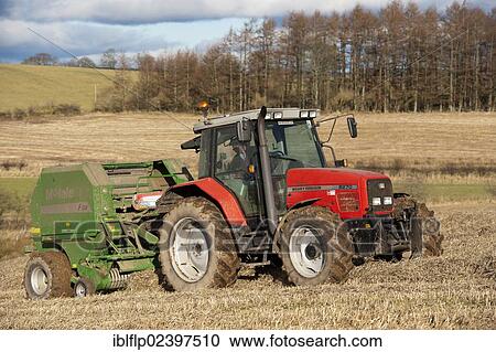 Stock Image - "Massey Fergusson tractor with McHale round baler, baling straw in stubble field, Scotland, United Kingdom, Europe". Fotosearch