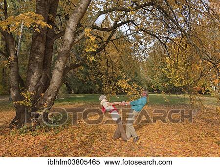 "Mature couple hand in hand under a tree in autumn, Lower Saxony, Germany, Europe" View Large Photo Image Stock Photography - "Mature couple hand in hand under a tree in autumn, Lower Saxony, Germany, Europe". Fotosearch