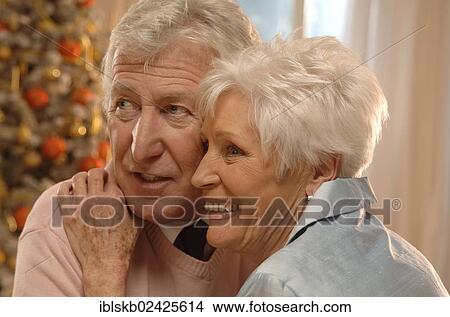 Mature couple in love in front of a Christmas tree View Large Photo Image Picture - Mature couple in love in front of a Christmas tree. Fotosearch