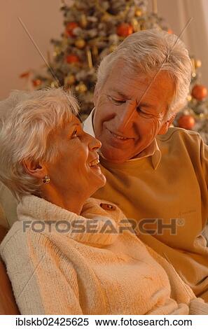 Mature couple in love sitting in front of a Christmas tree View Large Photo Image Stock Photography - Mature couple in love sitting in front of a Christmas tree. Fotosearch