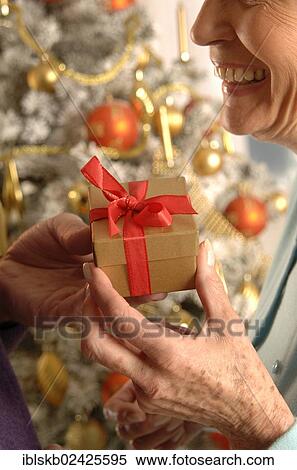 Mature woman receiving a Christmas present View Large Photo Image Stock Photography - Mature woman receiving a Christmas present. Fotosearch