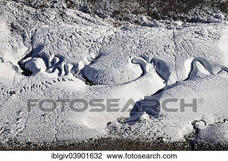 Stock Image - "Meandering meltwater stream in glacial ice, Gornergrat Ridge, Zermatt, Canton of Valais, Switzerland, Europe". Fotosearch