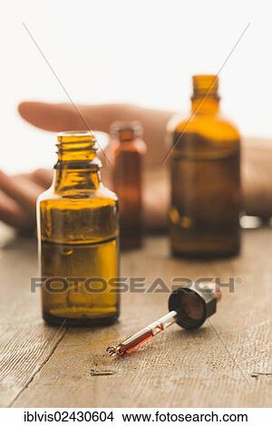 Medical bottles and pipette containing toxic fluid with hand of a victim of a crime in the back View Large Photo Image Picture - Medical bottles and pipette containing toxic fluid with hand of a victim of a crime in the back. Fotosearch