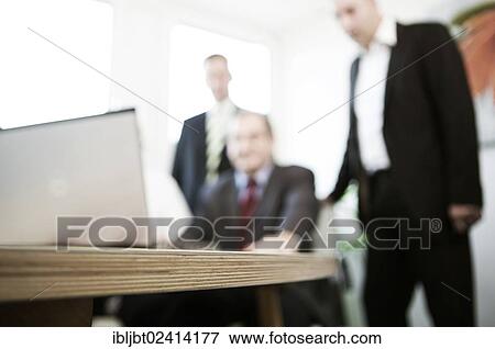 Meeting around a notebook in a conference room View Large Photo Image Stock Photo - Meeting around a notebook in a conference room. Fotosearch