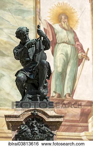 Stock Photograph - "Memorial for violin maker Matthias Klotz, behind Luftlmalerei of the Apostle Paul, parish church of St. Peter and Paul, Mittenwald, Werdenfelser Land, Upper Bavaria, Bavaria, Germany, Europe". Fotosearch