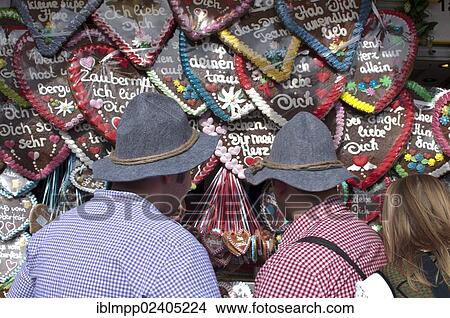 Picture - "Men buying an Oktoberfest ginger heart, Oktoberfest, Munich, Bavaria, Germany, Europe". Fotosearch