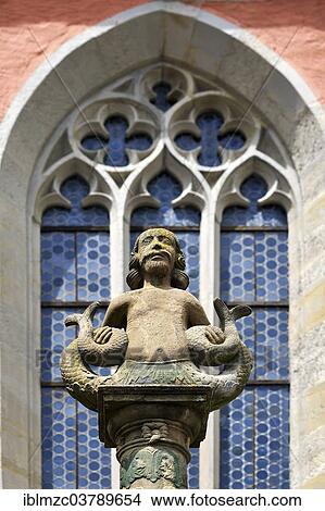 Picture - "Merman, sculpture on the Johannisbrunnen fountain, gothic tracery window of the St. John church behind, 14 Century, Rothenburg ob der Tauber, Middle Franconia, Bavaria, Germany, Europe". Fotosearch