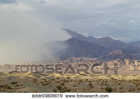"Mesquite Flat Sand Dunes, a sand storm over the Grapevine Mountains in the back, Death Valley, Death Valley National Park, California, USA" View Large Photo Image Stock Photo - "Mesquite Flat Sand Dunes, a sand storm over the Grapevine Mountains in the back, Death Valley, Death Valley National Park, California, USA". Fotosearch