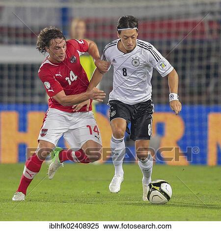 Stock Photography - "Mesut Oezil, #8 Germany, and Julian Baumgartlinger, 14 Austria, fight for the ball during the WC qualifier soccer game on September 11, 2012 in Vienna, Austria, Europe". Fotosearch