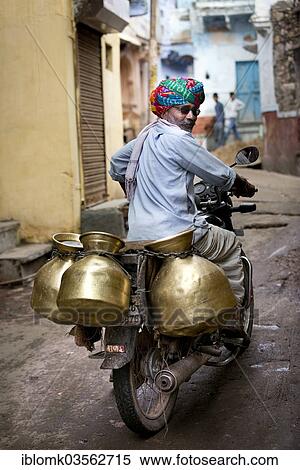 Stock Photography - "Milkman riding a motorcycle with milk containers, Bundi, Rajasthan, India, Asia". Fotosearch
