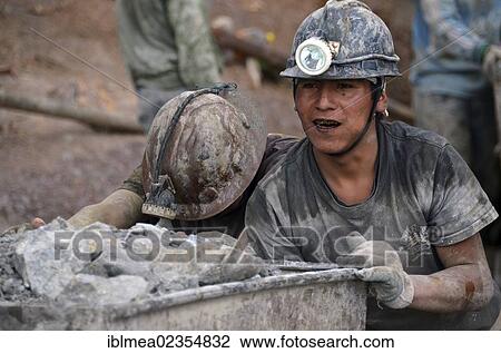 Stock Image - "Miners pushing a trolley at Cerro Rico, the rich mountain, silver mine in Potosi, Bolivia, South America". Fotosearch