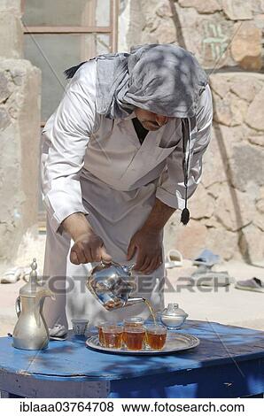 Stock Photo - "Modern Bedouin man preparing tea, Sinai Peninsula, Egypt, Africa". Fotosearch