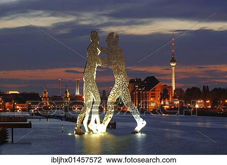 Stock Image - "Molecule Men, sculpture by American artist Jonathan Borofsky, standing in the Spree river, overlooking the Oberbaumbruecke bridge, Osthafen harbor, Friedrichshain and tv tower, Treptow district, Berlin, Germany, Europe". Fotosearch