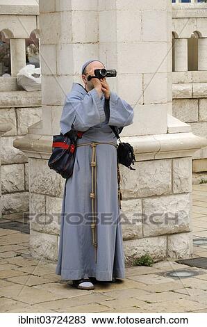 Stock Image - "Monk filming with a video camera, Nazareth, Israel, Asia". Fotosearch