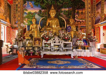Stock Photo - "Monk, novice praying in front of a Buddha statue at Wat Sriboonruang, Sri Boon Ruang Temple, Chiang Rai, Northern Thailand, Thailand, Asia". Fotosearch