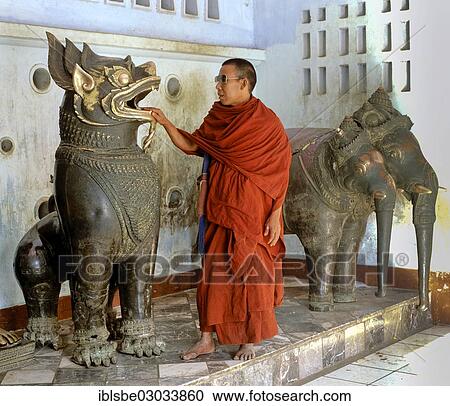 "Monk placing his hand into the mouth of a lion statue, in front of a statue of Airavata, the three-headed elephant, Khmer bronze statues, Mahamuni Pagoda, Mandalay, Mandalay Division, Myanmar, Burma, Asia" View Large Photo Image Stock Image - "Monk placing his hand into the mouth of a lion statue, in front of a statue of Airavata, the three-headed elephant, Khmer bronze statues, Mahamuni Pagoda, Mandalay, Mandalay Division, Myanmar, Burma, Asia". Fotosearch