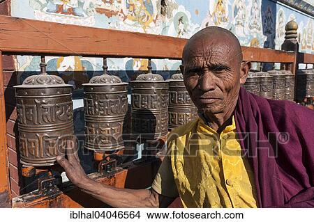 Picture - "Monk turning prayer wheels, Boudhanath Stupa, Kathmandu, Nepal, Asia". Fotosearch